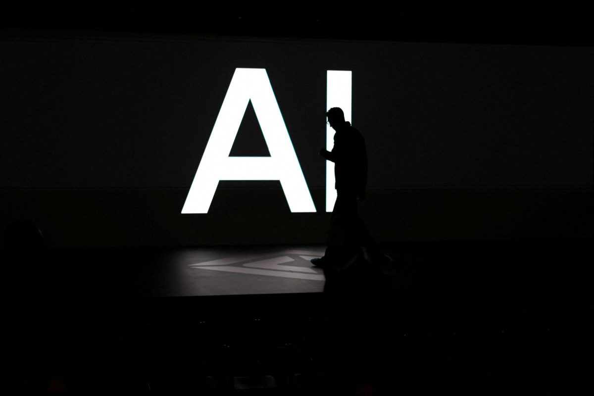 A screen reads 'AI' in reference to artificial intelligence as attendees gather during Rivian's first Autonomy and AI Day, showcasing developments in self-driving technology, in Palo Alto, California, U.S., December 11, 2025. REUTERS/Carlos Barria
