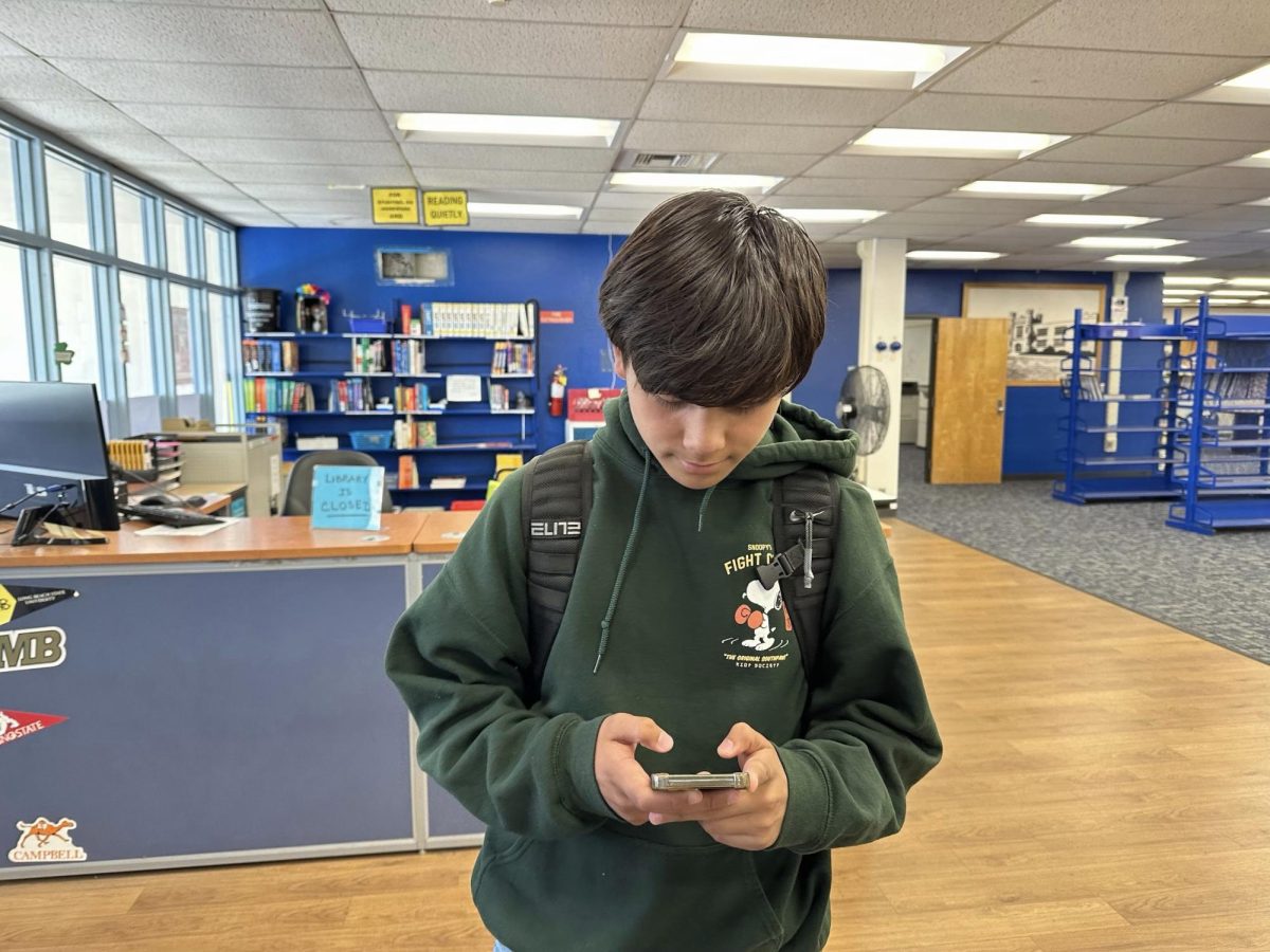 A photograph of a SDHS senior using social media during school.